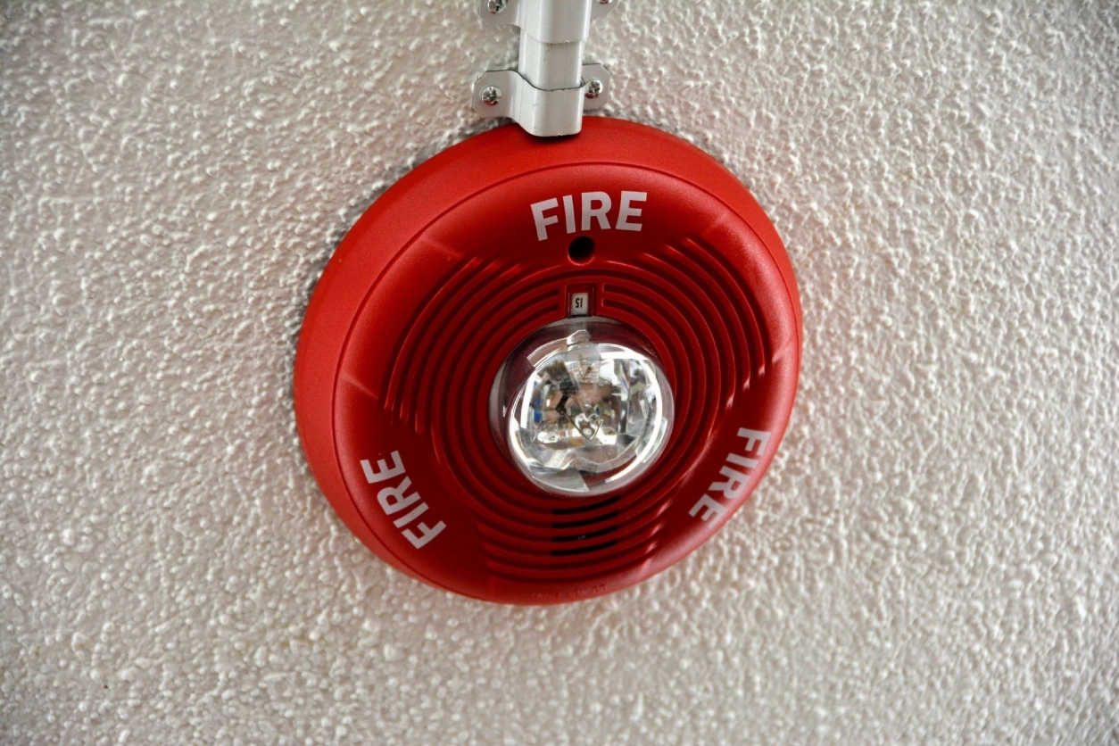 A red fire alarm on the wall of a building.